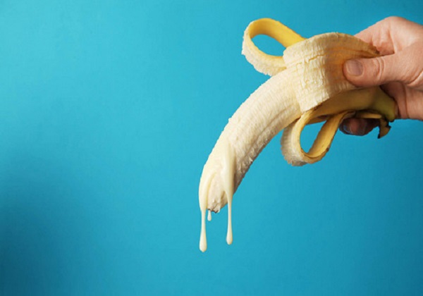 Big Banana And Drops Of Condensed Milk. Concept Of Sex, Man Ejaculation. Sperm And Orgasm
